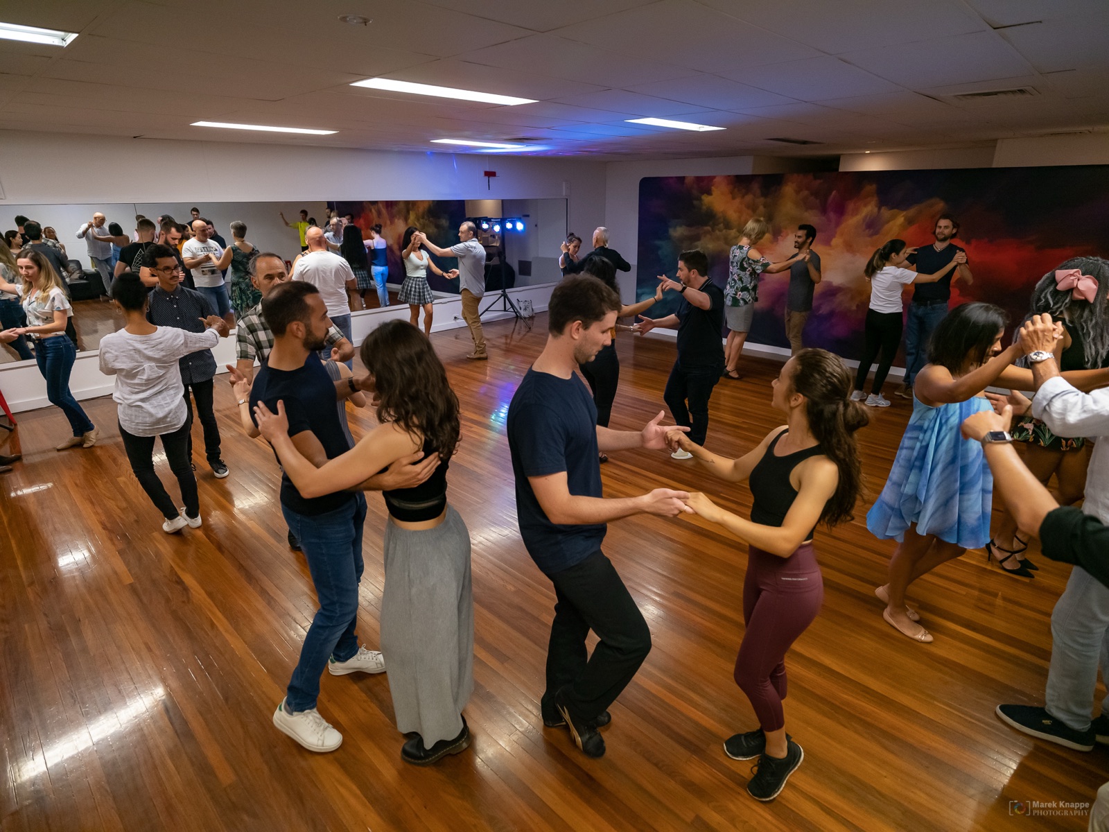 Studio 2 at Dance Culture Annerley: dancers on the hardwood floor in front of mirrors and a colourful mural wall